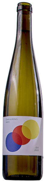 A green, long wine bottle with a white label that has three circles arranged diagonally on it. The circles are blue, red and yellow and a little transparent. The font is small an put unto the upper left- and the lower right corner. There`s wine in it and no cork